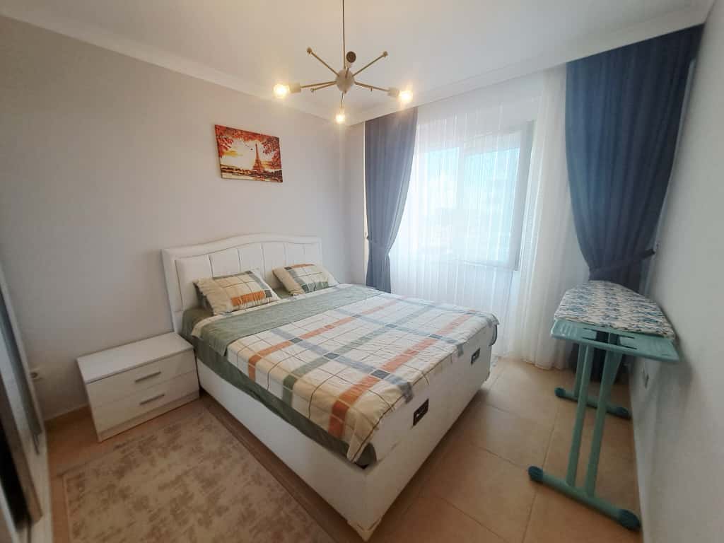 Çift kişilik yatak ve ekose örtülü yatak odası, Alanya’daki dairede