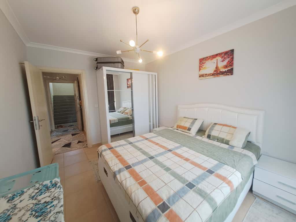 Aynalı kapaklı gardırop ve çift kişilik yataklı yatak odası, apartman dairesinde