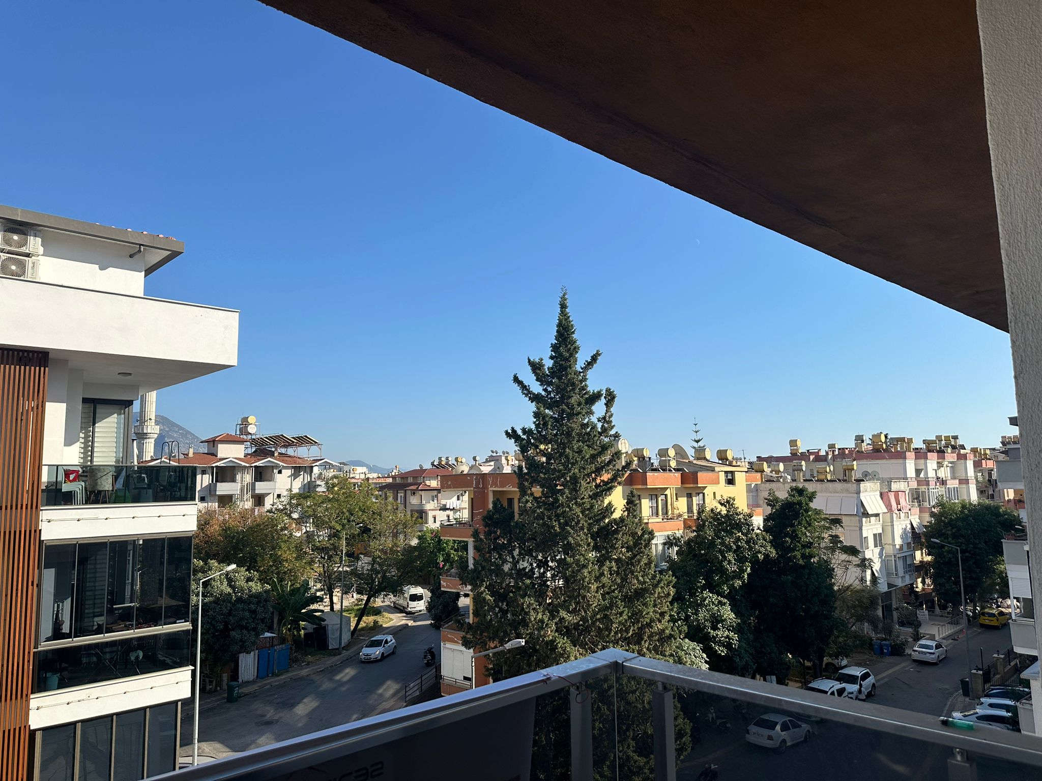 Türkiye’de satılık dairenin balkonunda cam korkuluk ve şehir yapılarına bakan açık manzara