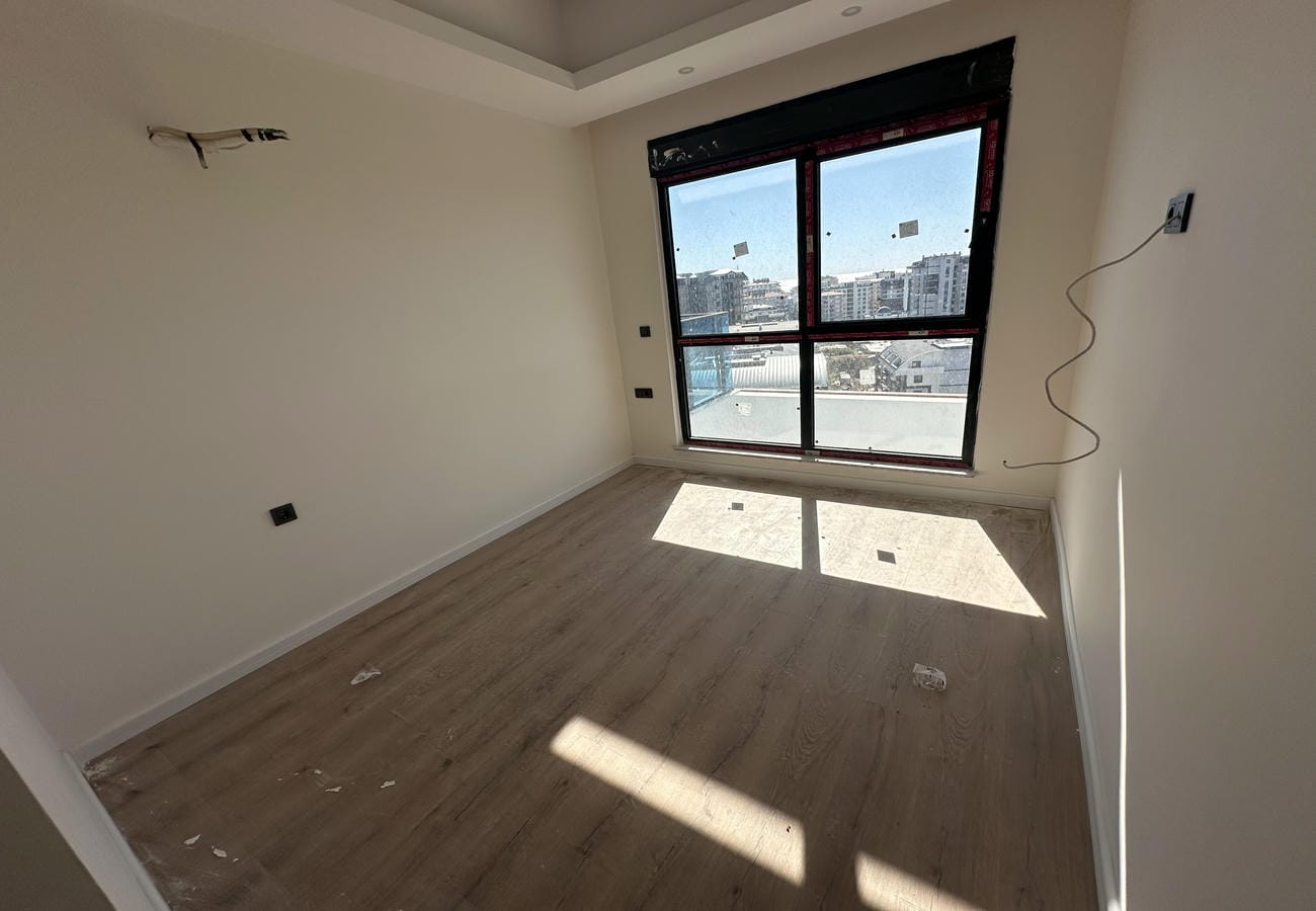 Mahmutlar’da satılık 2+1 dairede panoramik pencereli ve güneş gölgeli boş salon
