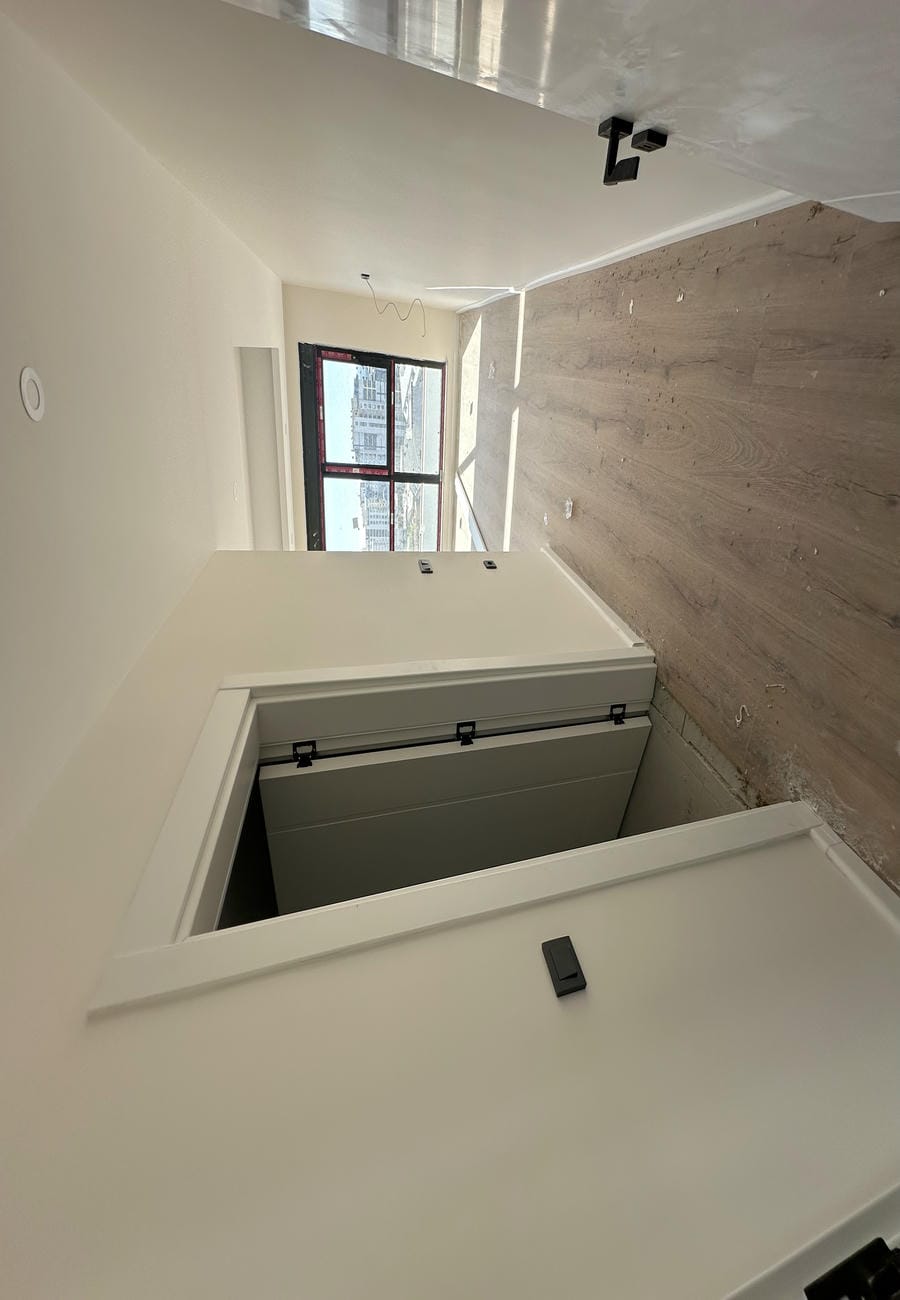 Apartman dairesinde ahşap görünümlü zeminli uzun koridor ve uçta panoramik pencere