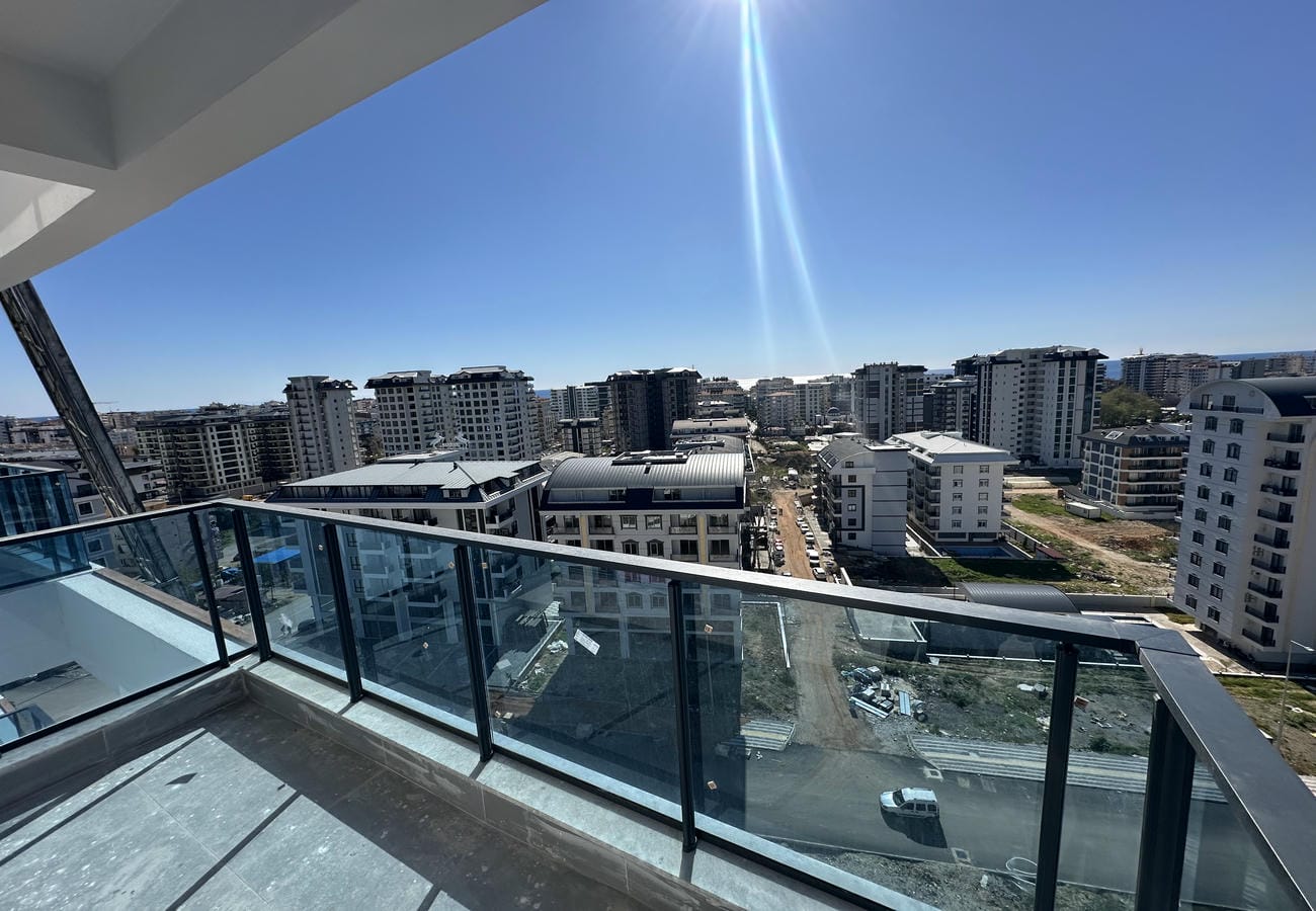 Alanya’da Türkiye’de cam korkuluklu balkon, şehir yapılaşması ve aşağıda şantiye görünümü