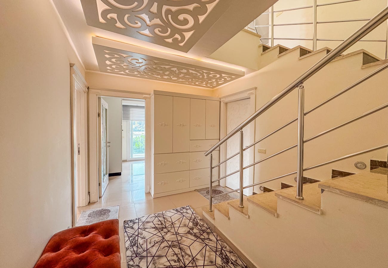 Mermer basamaklı antrede beyaz gömme dolap ve metal korkuluklu iç merdiven, penthouse içinde
