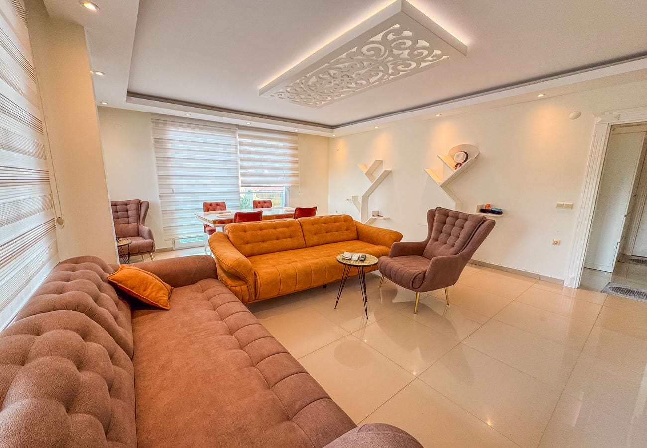 Köşe kanepeli salonda panoramik pencere ve duvar rafları, satılık penthouse içinde
