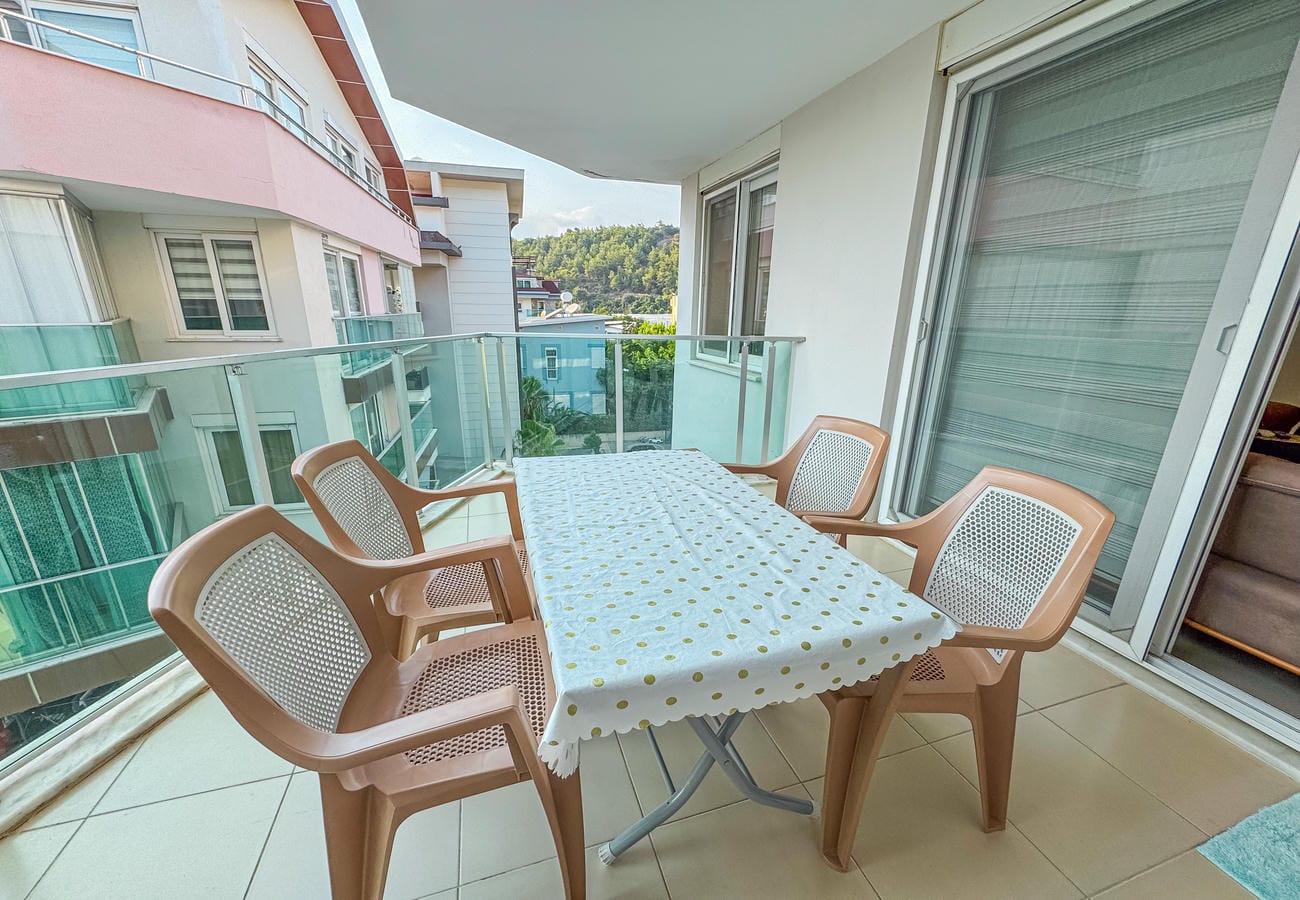 Yemek masalı terasta cam korkuluk ve komşu yapılar manzarası, penthouse dairede