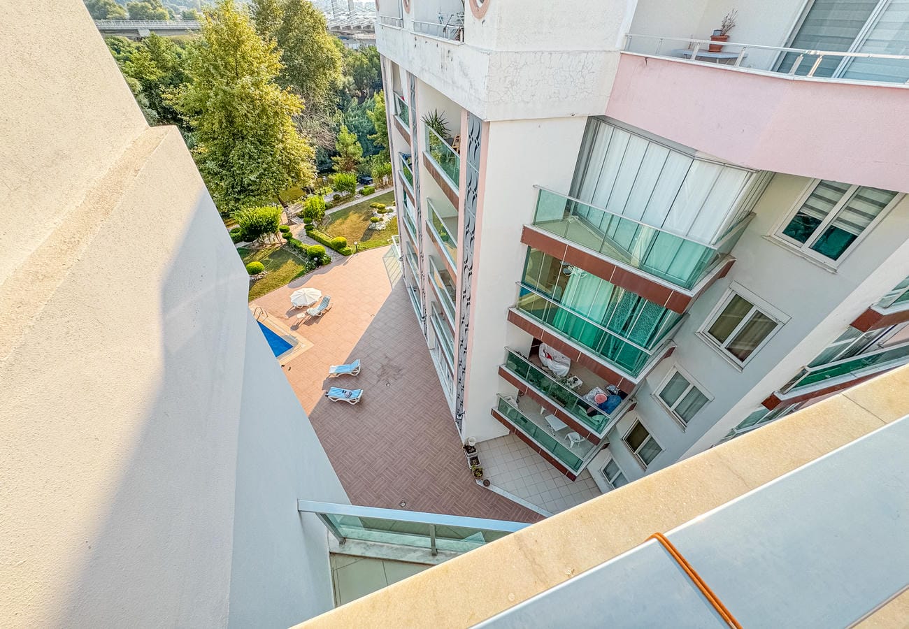 Balkondan aşağıdaki havuz ve yeşil bahçe yollarına bakış, Kestel’deki penthouse dairede