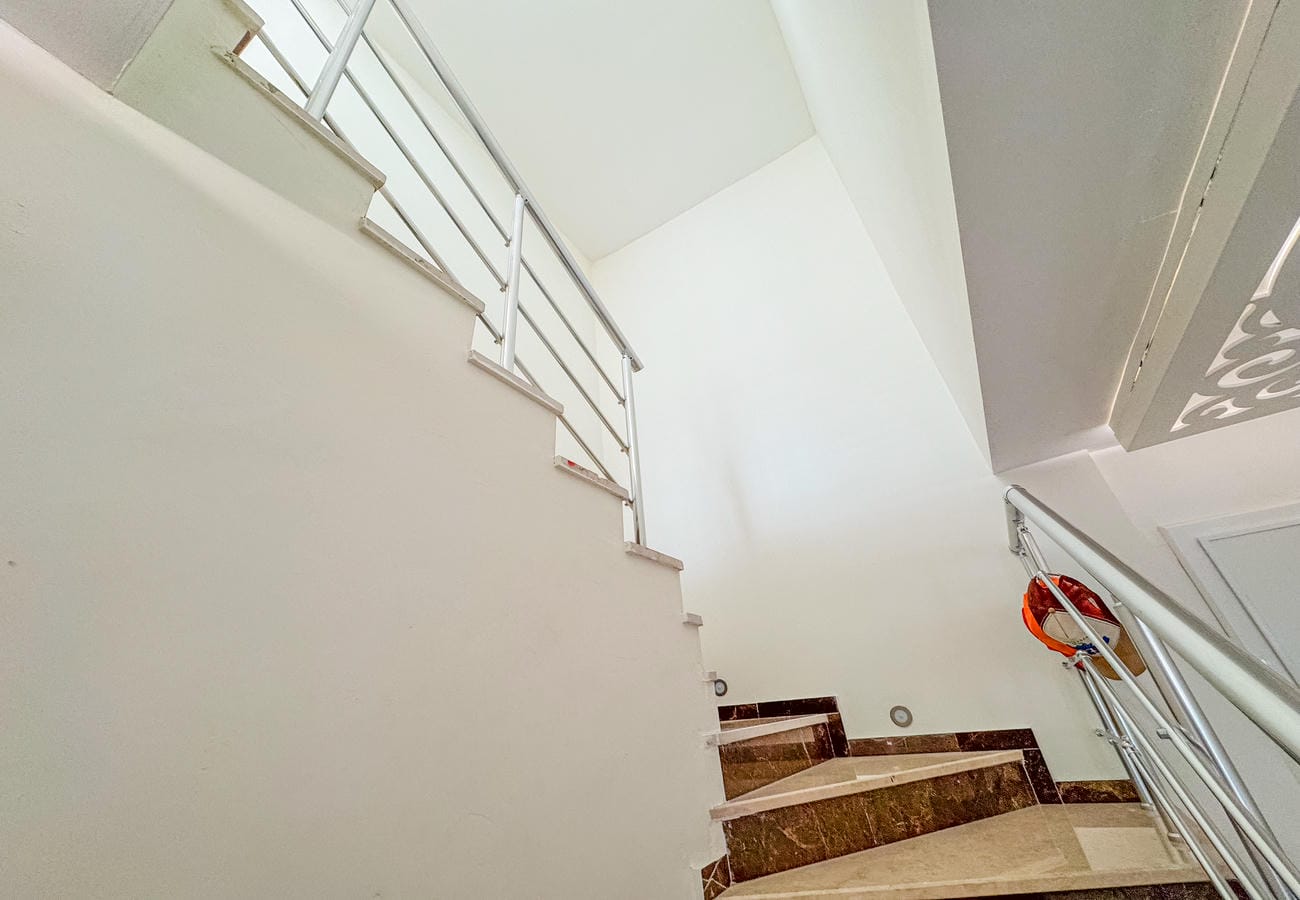 Dönüş sahanlıklı mermer kaplı merdiven ve metal korkuluk, penthouse dairede