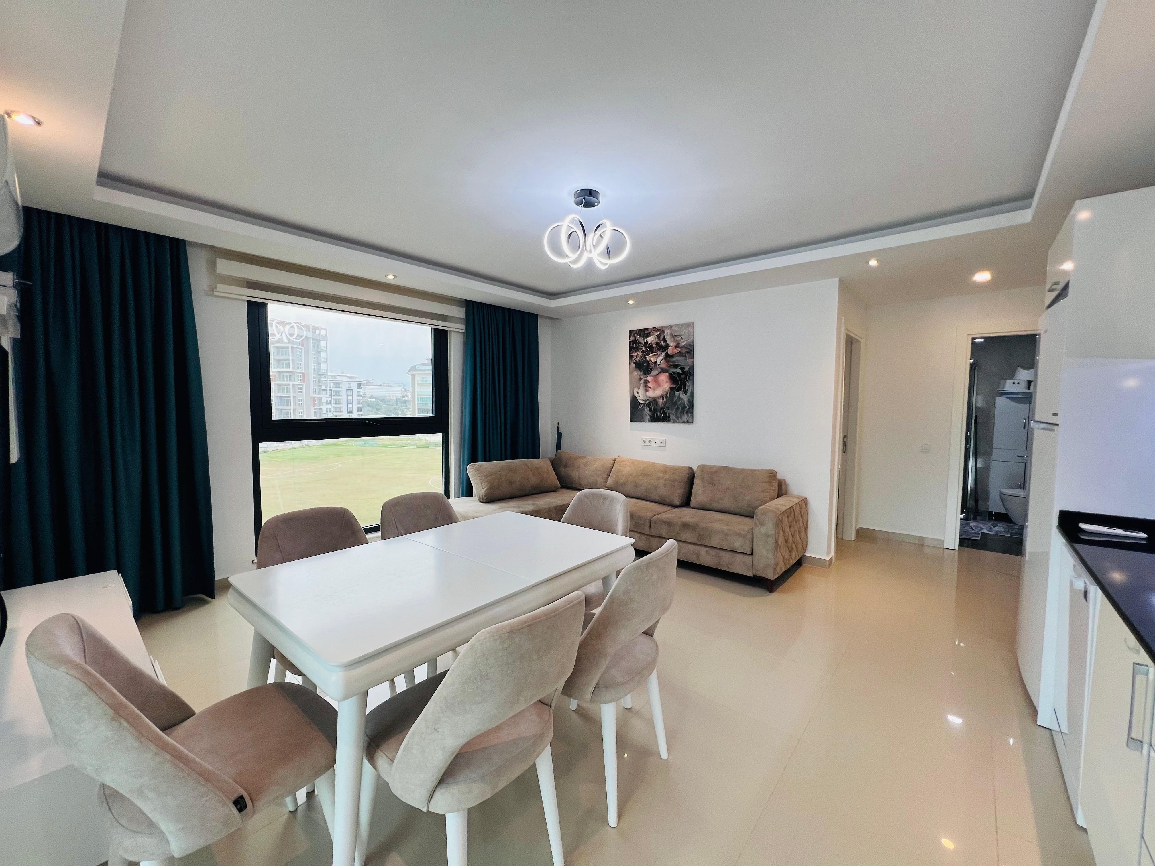 Kitchen-living room with a white table and beige sofa in an apartment for sale in Turkey