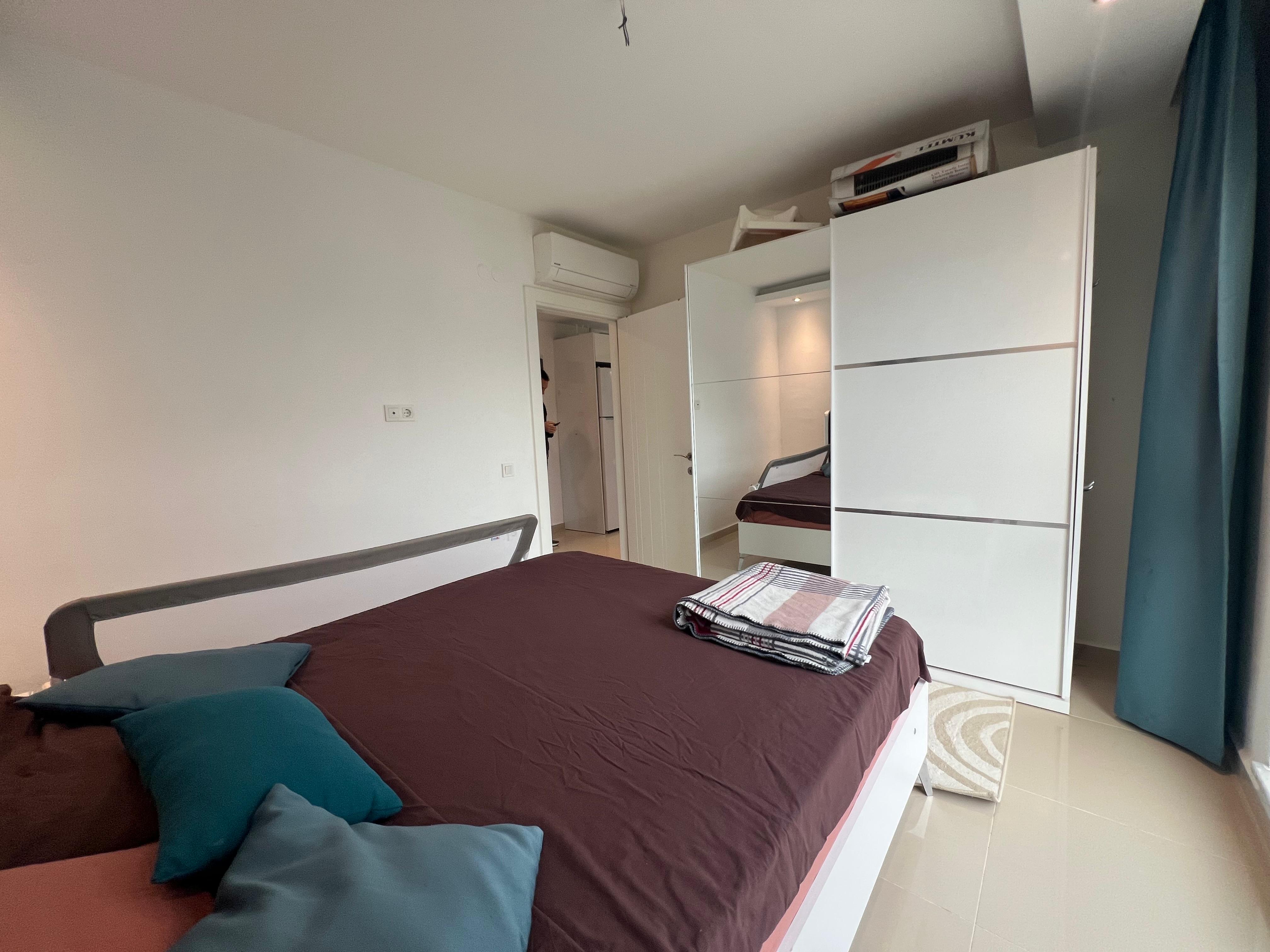 Bedroom with a double bed and a tall wardrobe with mirrored doors