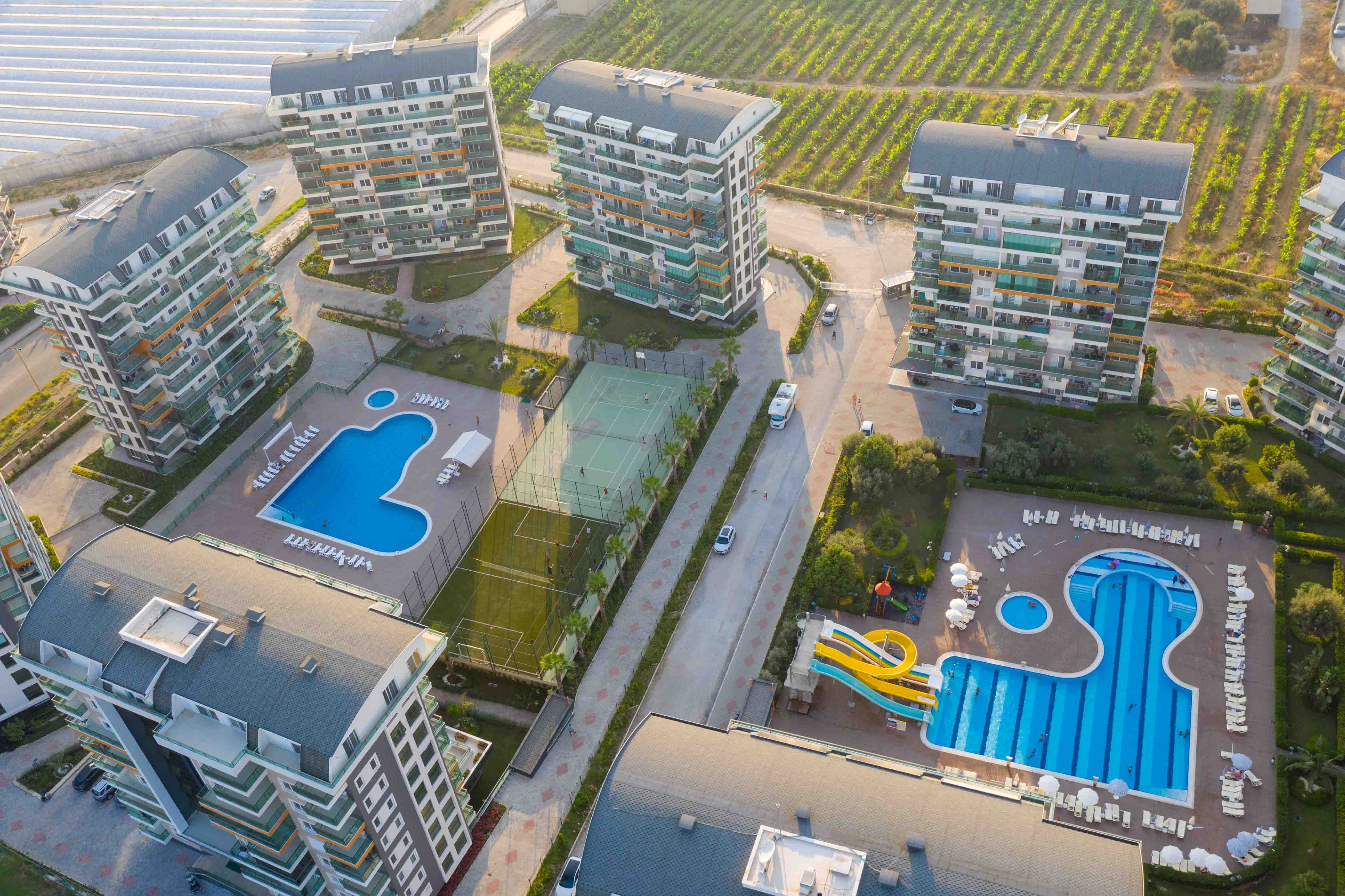Two outdoor pools with water slides at a complex with apartments for sale in Turkey