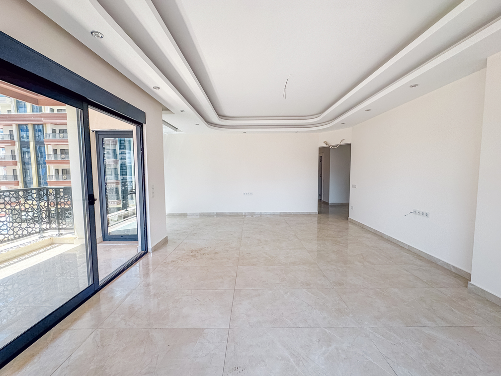 Daire salonunda geniş panoramik pencere, açık balkon kapısı ve spot ışıklı tavan