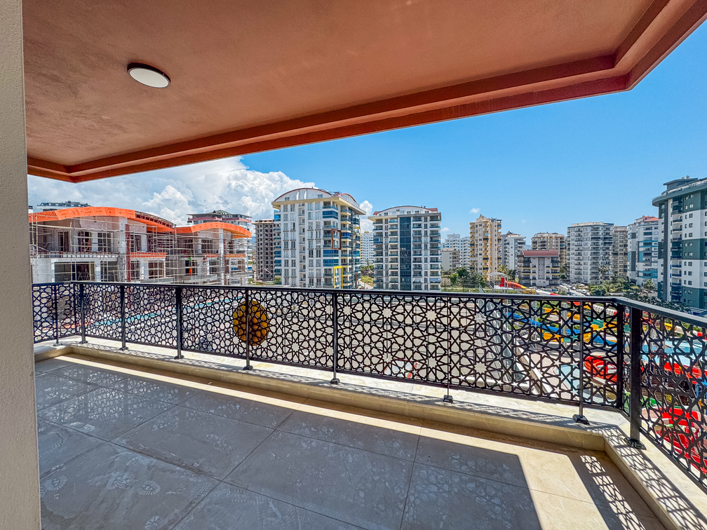 Türkiye’de Mahmutlar’daki dairenin geniş balkonunda ajurlu korkuluk ve binalara panoramik bakış