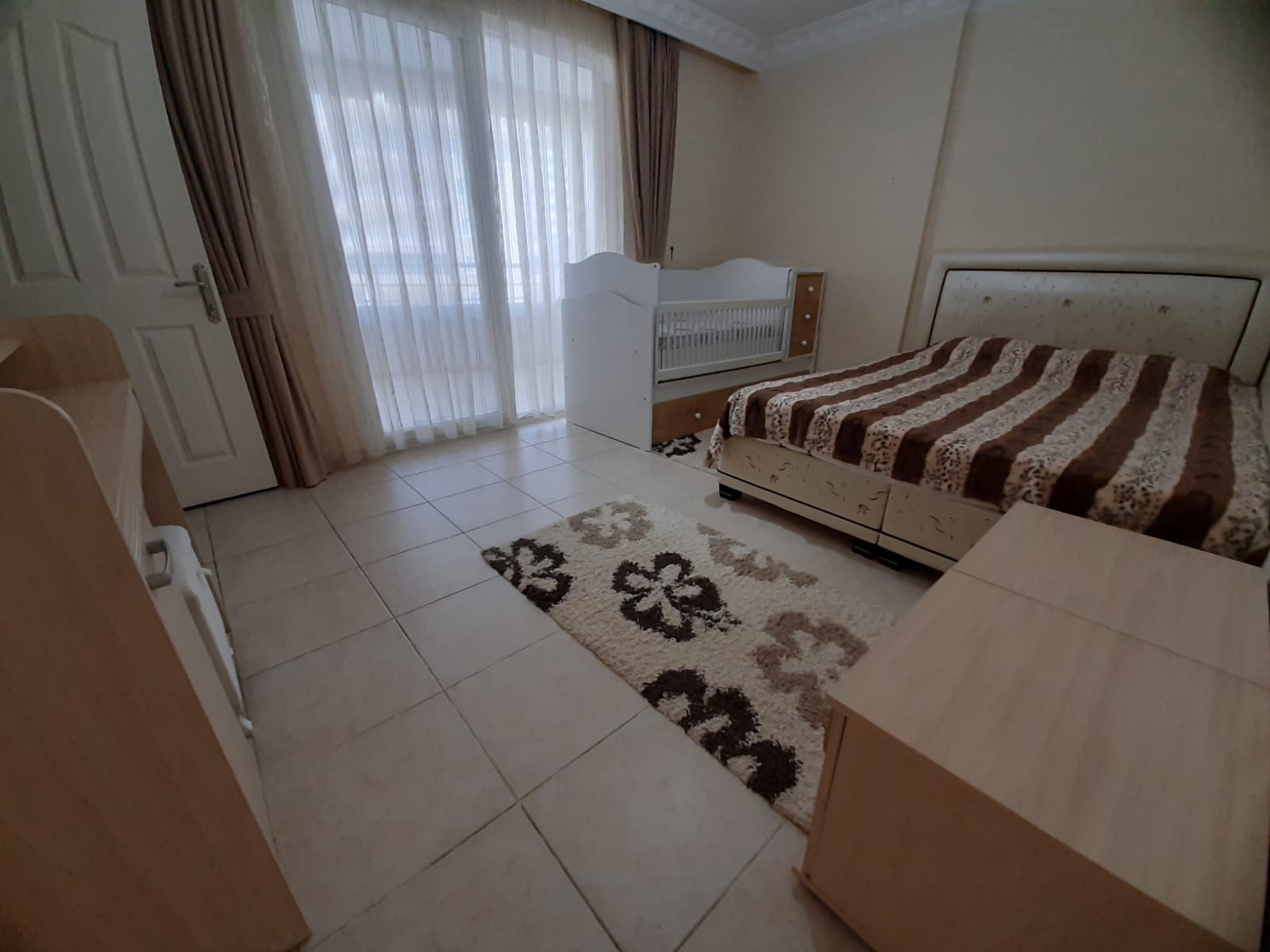 2+1 dairenin yatak odasında çift kişilik yatak, bebek yatağı ve panoramik pencere