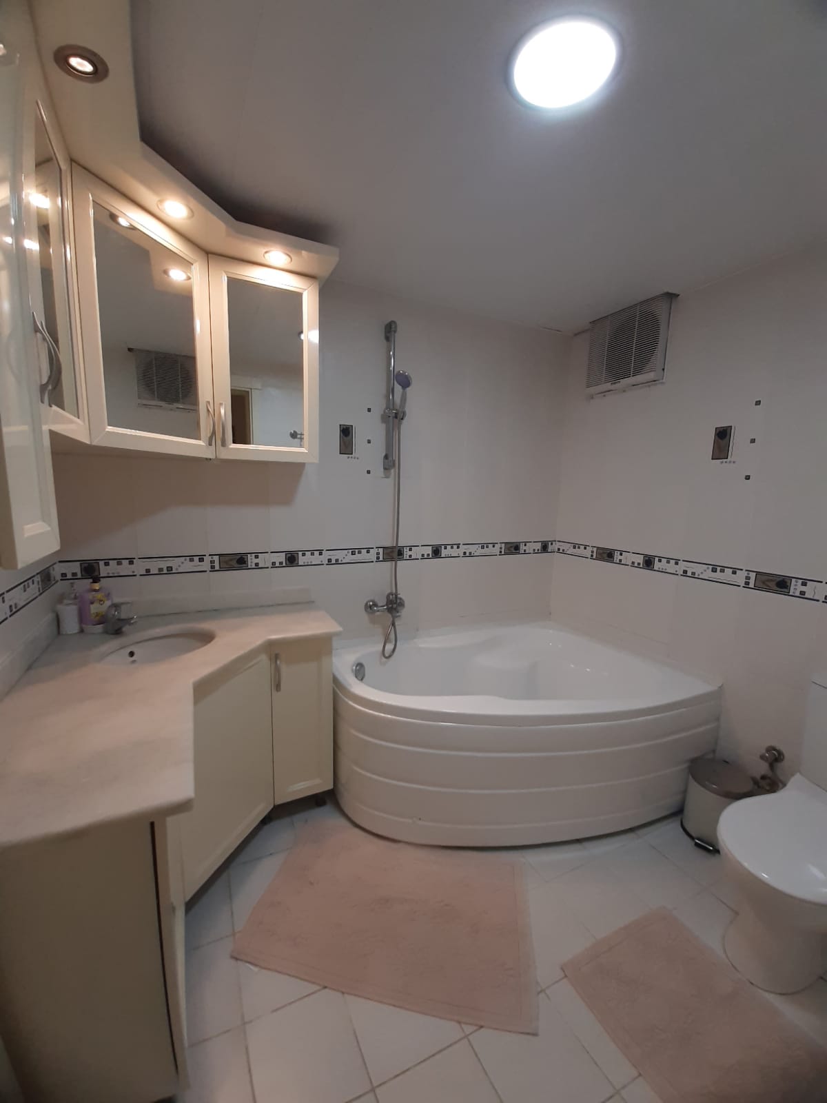 2+1 dairenin banyosunda köşe hidromasaj küveti, uzun lavabo dolabı ve aynalı dolap