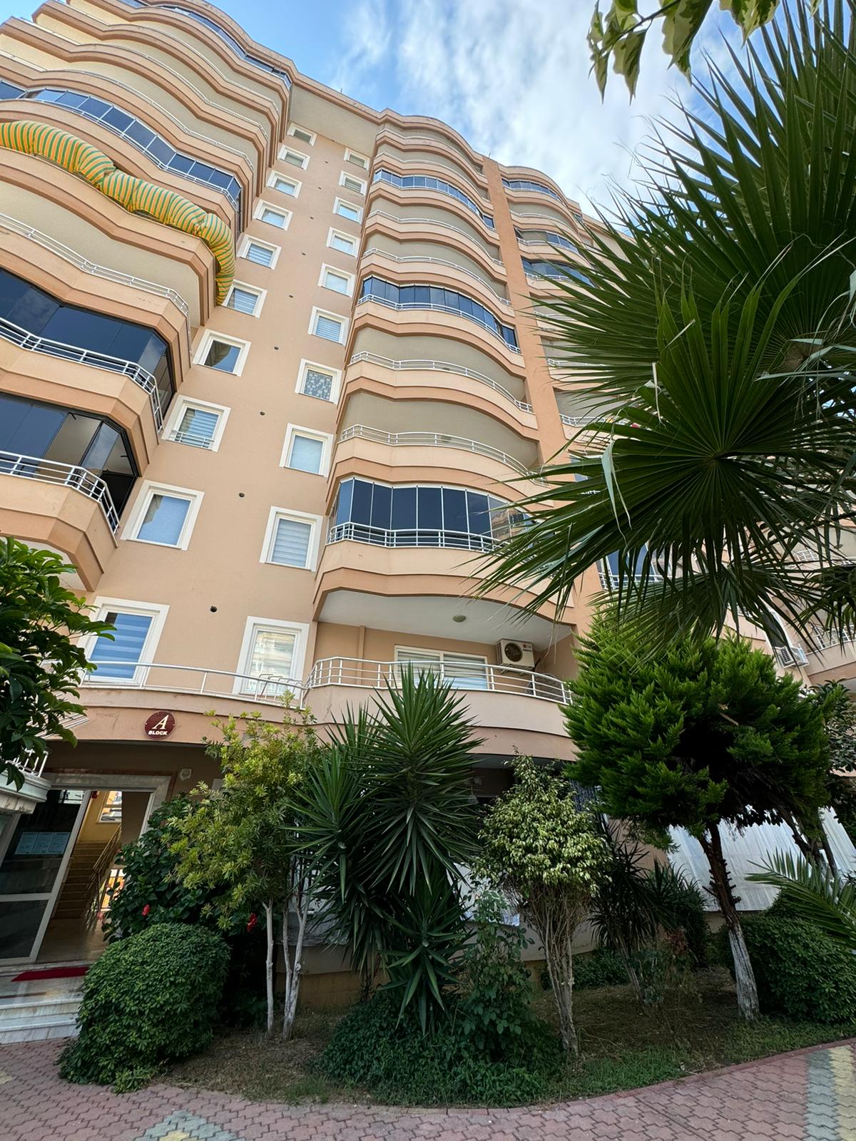 Türkiye’de satılık 2+1 dairenin bej cephesinde beyaz korkuluklu dalgalı balkonlar