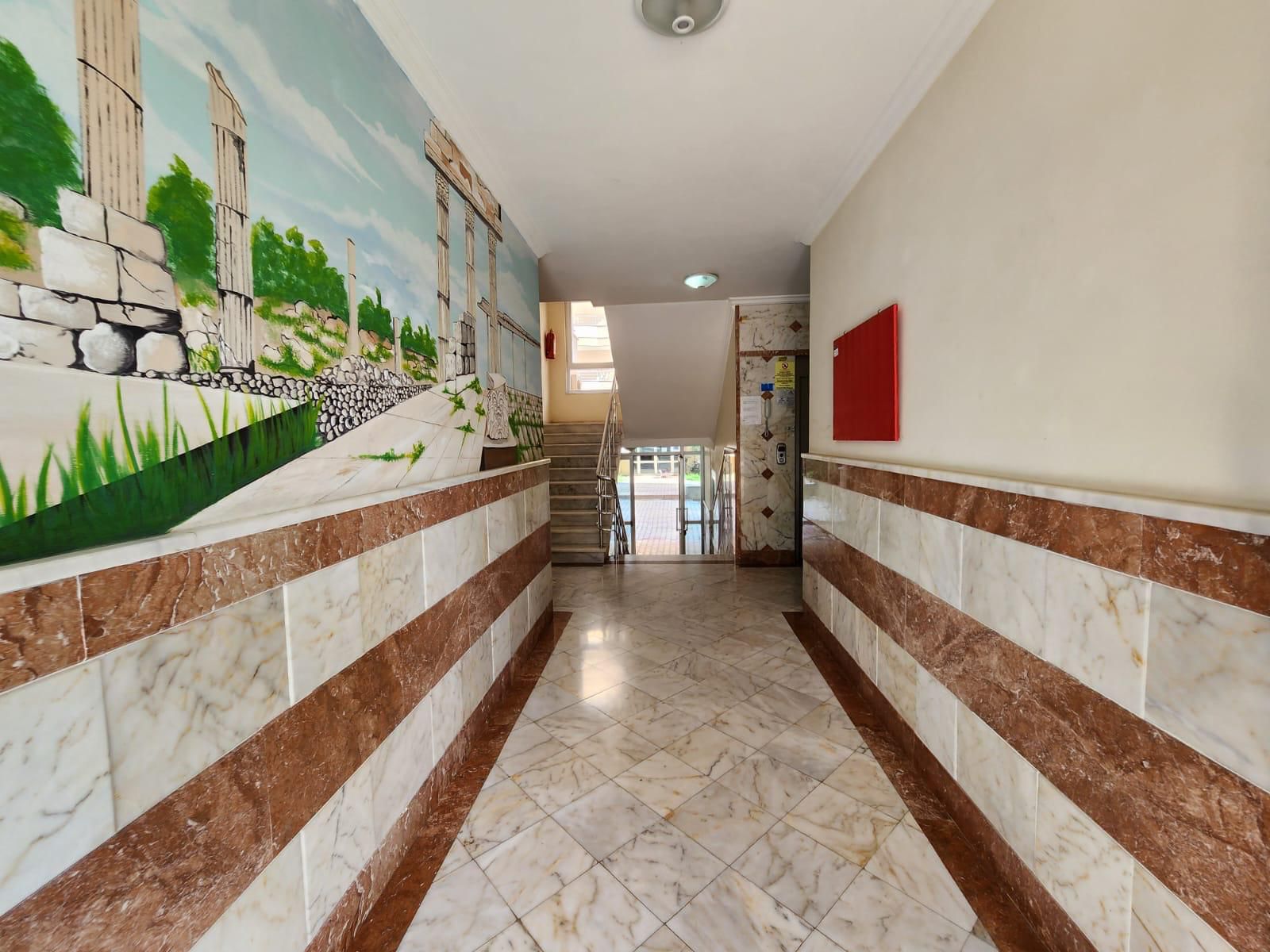 Mahmutlar’da mermer duvarlı apartman koridorunda merdiven ve antik harabe duvar resmi