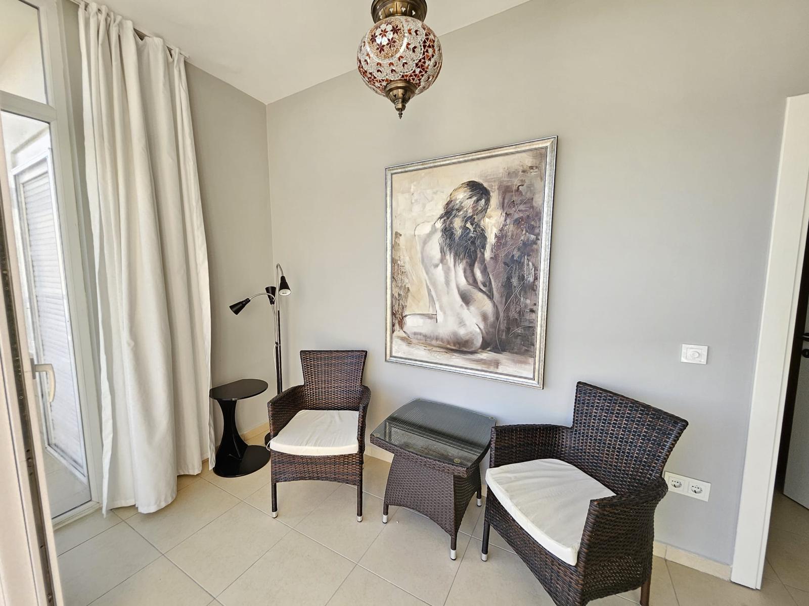 Penthouse salonunda hasır koltuklar, ikili kanepe ve beyaz perdeli panoramik pencere
