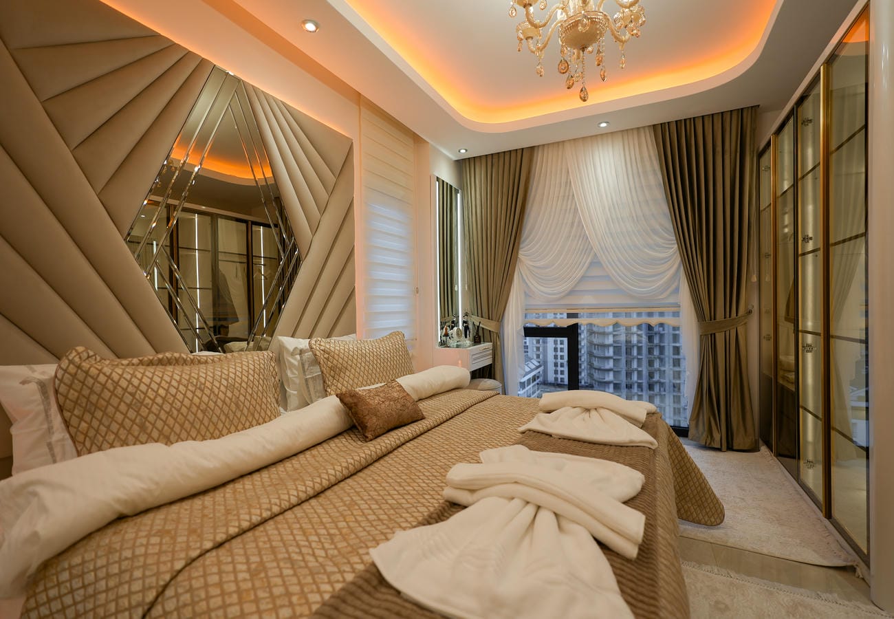 Mahmutlar’daki penthouse yatak odasında şehir manzaralı pencere ve cam kapaklı dolap