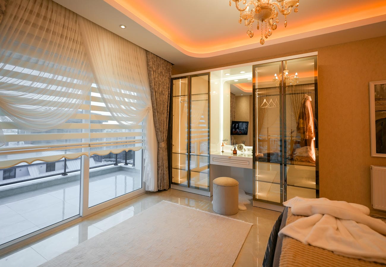 Penthouse yatak odasında sürgülü kapılı cam giyinme dolabı ve balkona çıkış
