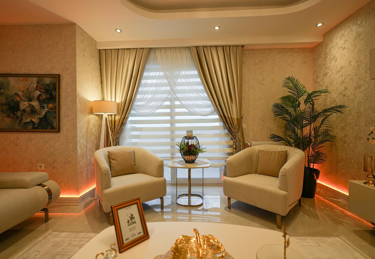Türkiye’de satılık penthouse salonunda pencere yanında iki açık renk koltuk