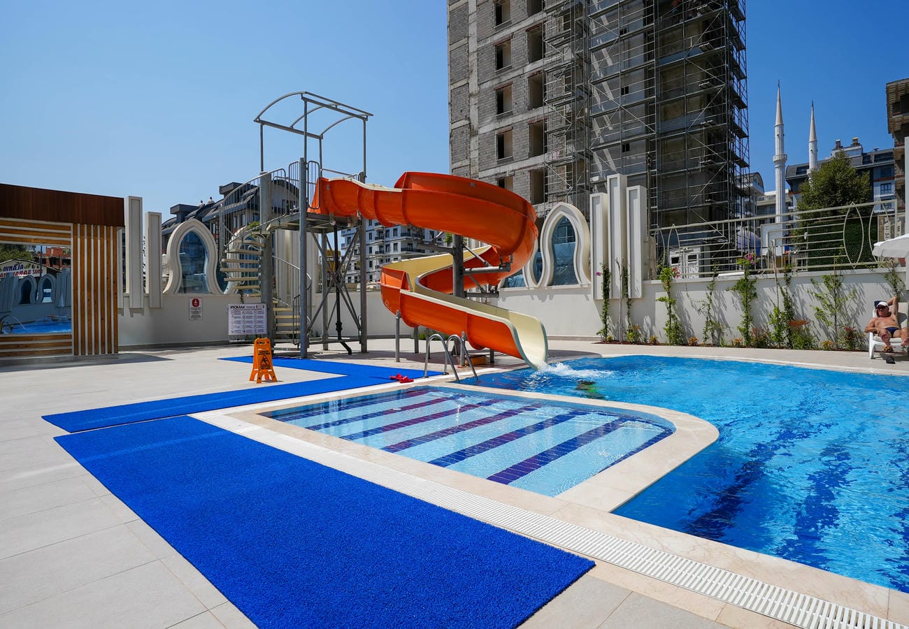 Mahmutlar’da satılık penthouse sakinleri için mozaik tabanlı küçük havuz ve spiral kaydırak