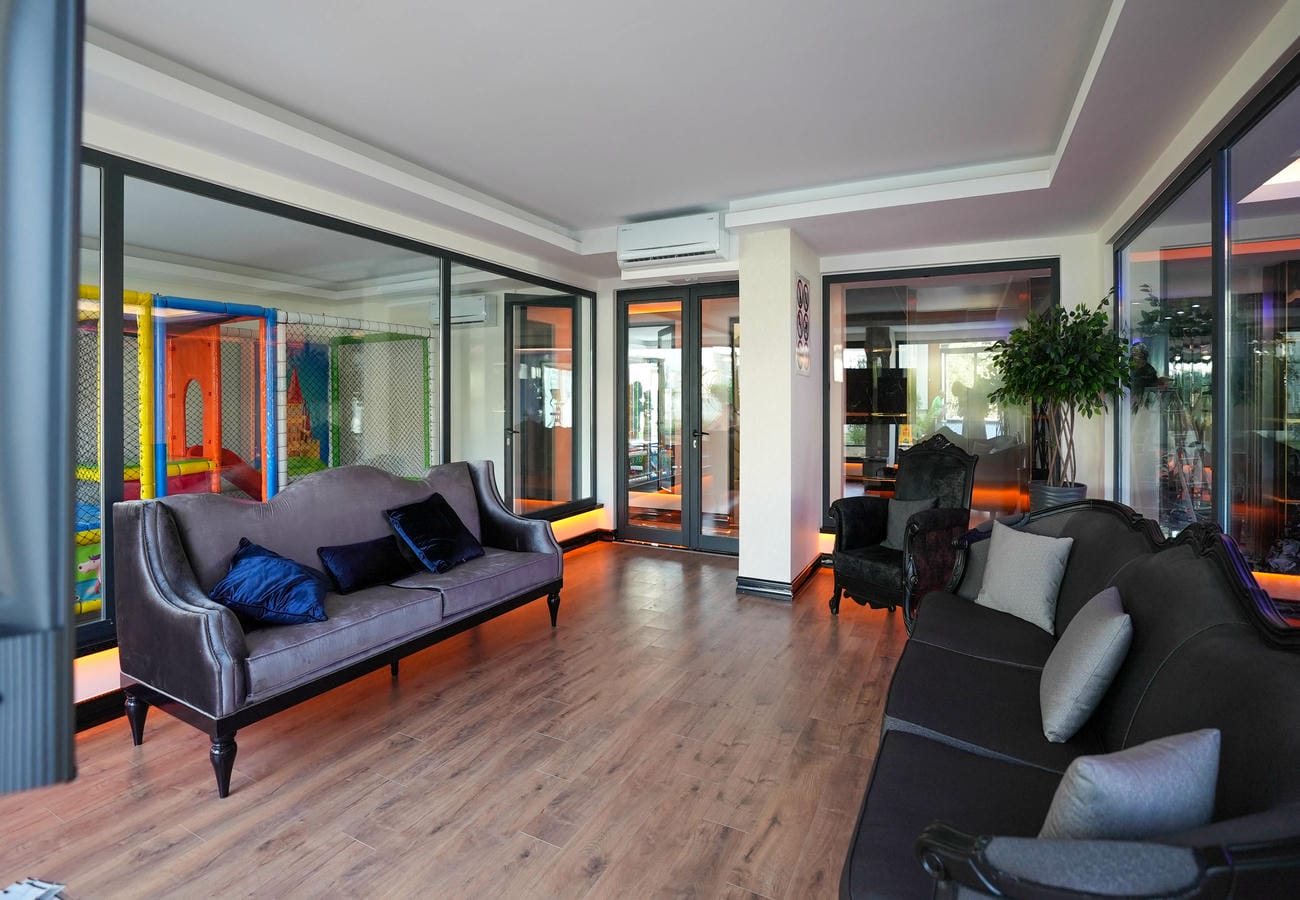 Mahmutlar’daki penthouse kompleksinin çocuk oyun odasında gri kanepe ve oyun labirenti