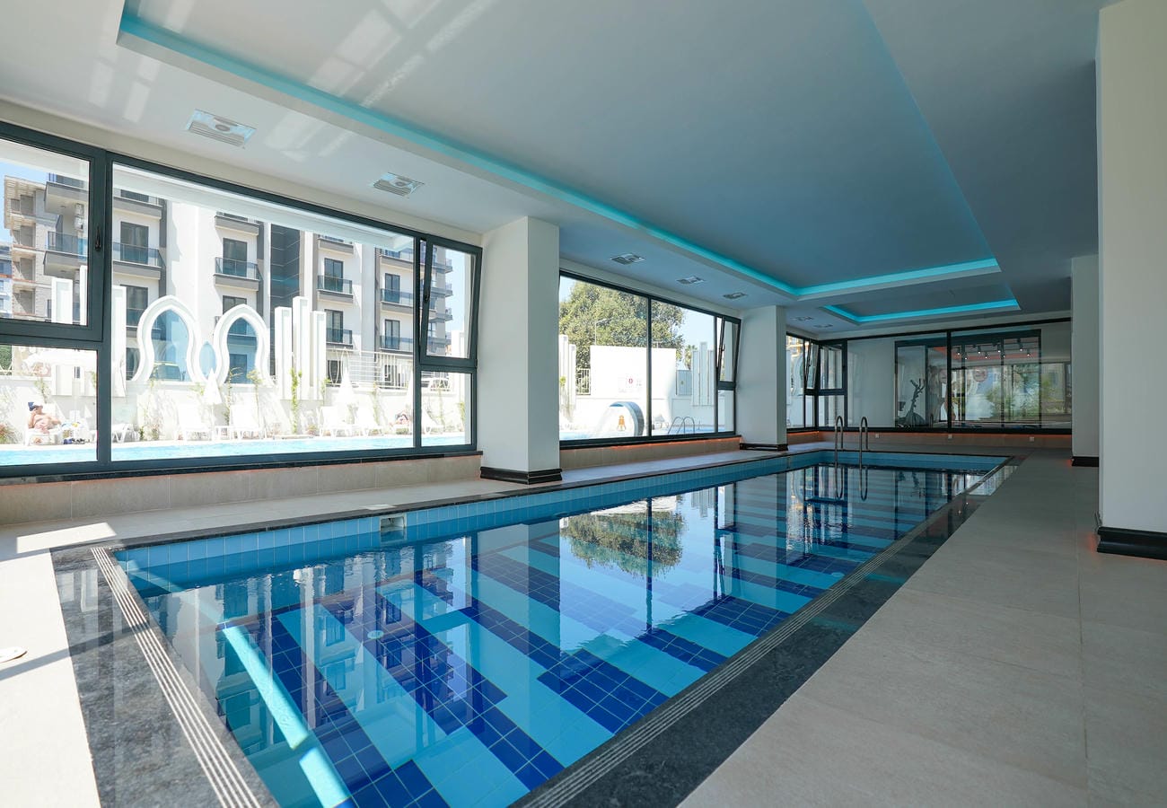 Mahmutlar’daki penthouse sakinleri için mavi mozaikli uzun kapalı havuz