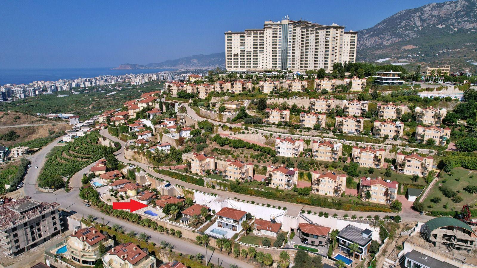 Hillside villa complex with red tile roofs and a sea bay in Mahmutlar, Turkey