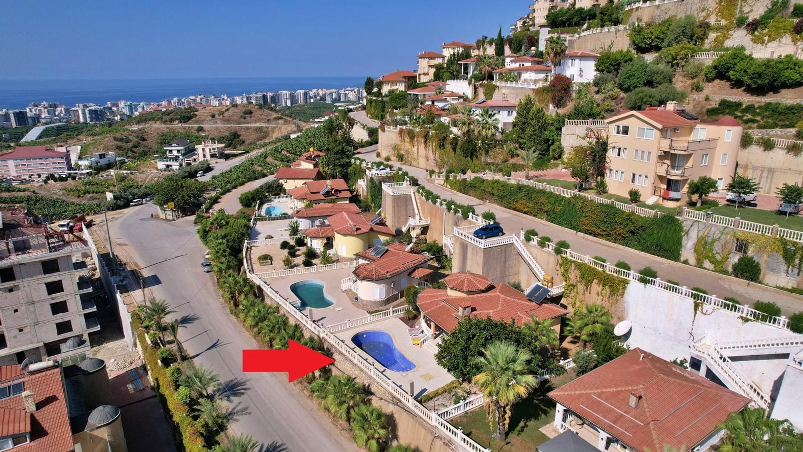 Villas for sale in Turkey feature individual pools on a landscaped slope with mountain views