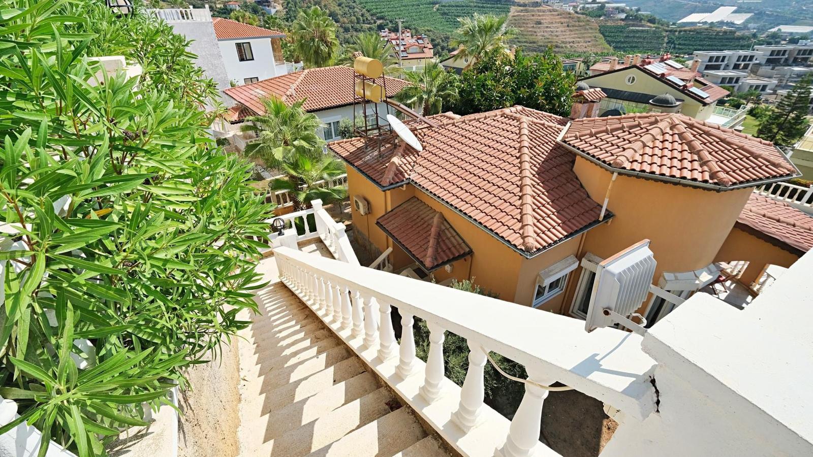 Outdoor stairway with white balustrades by homes for sale among palms and shrubs