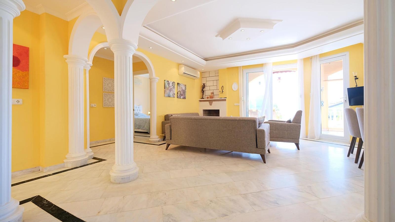 Kitchen-living room with gray sofa, marble floor and panoramic windows in Mahmutlar