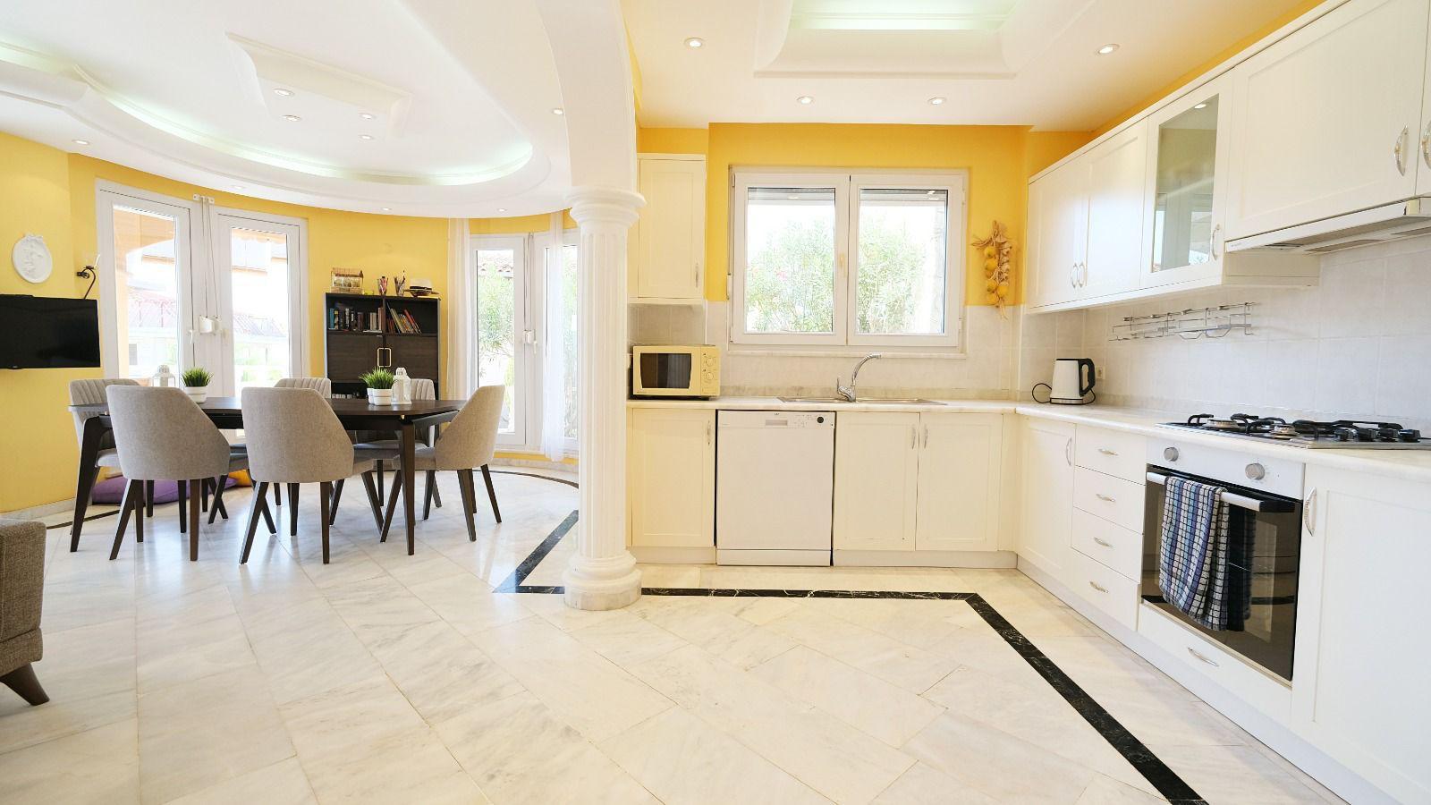 White kitchen with gas hob, oven and dishwasher in a villa in Mahmutlar