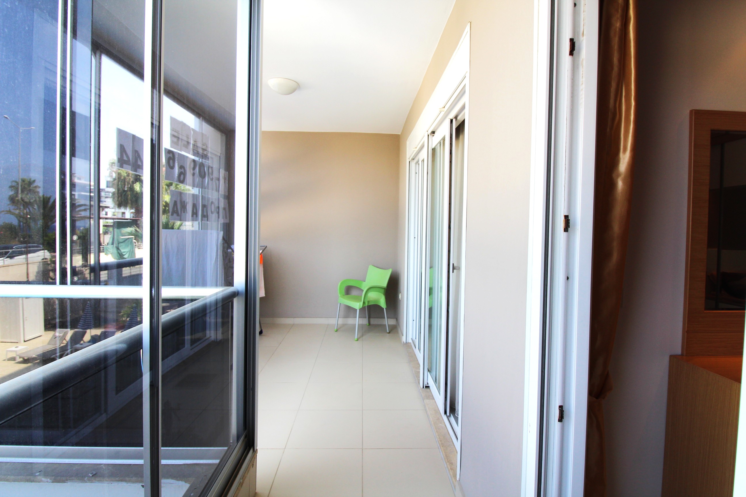 Sürgülü camlı kapalı balkon Kestel’de satılık konutun palmiyelere bakıyor