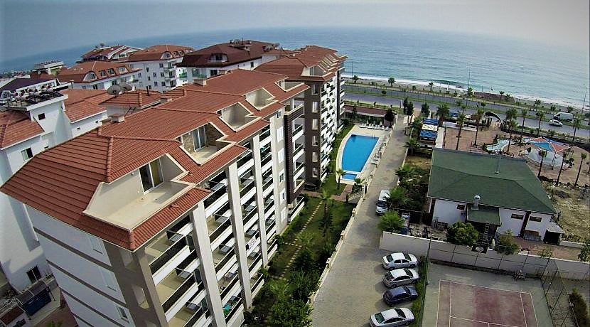 Kırmızı çatılı konutlar arasındaki havuzdan deniz manzarası Kestel’de satılık evler için