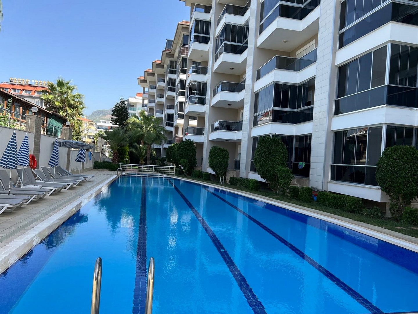 Merdivenli havuz ve çizgili şemsiyeler Kestel’de Türkiye’deki rezidans sakinleri için
