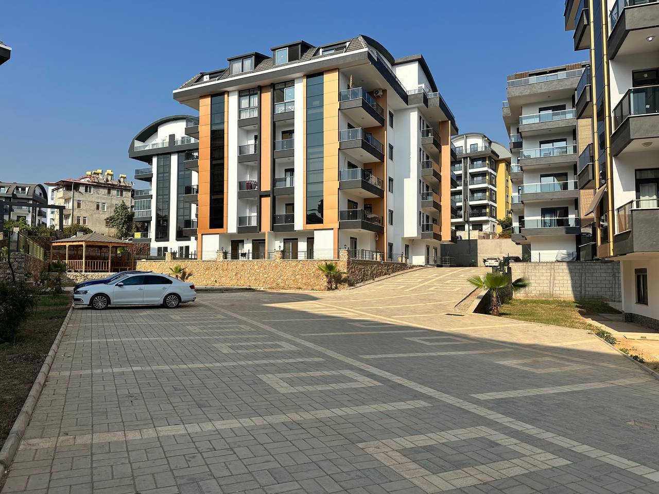 Sarı düşey panelli beş katlı bina: Alanya’nın Oba semtinde satılık 2+1 daire, Türkiye’de — New Level Group
