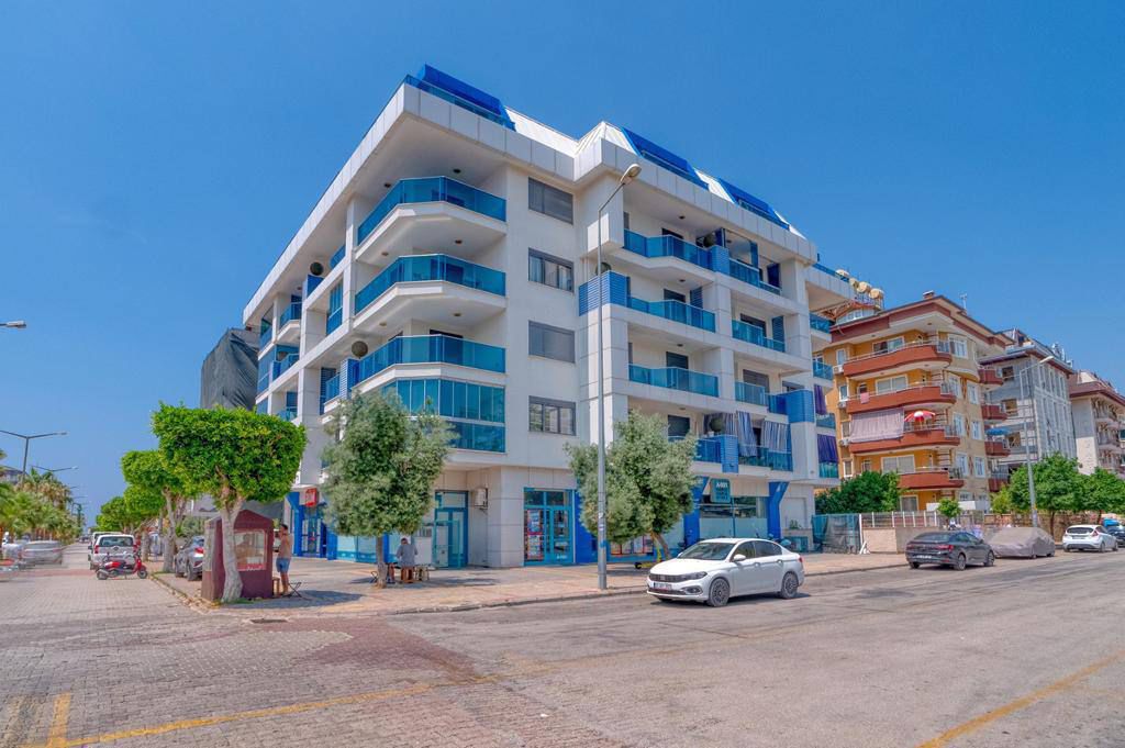 Mavi cam balkonlu beyaz cephe: Alanya’daki Oba’da satılık 2+1 daire, Türkiye — New Level Group