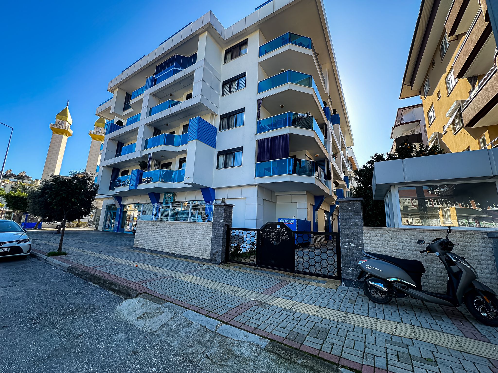 Oba’da satıştaki binanın geometrik desenli giriş kapısı ve mavi panelli köşe cephesi