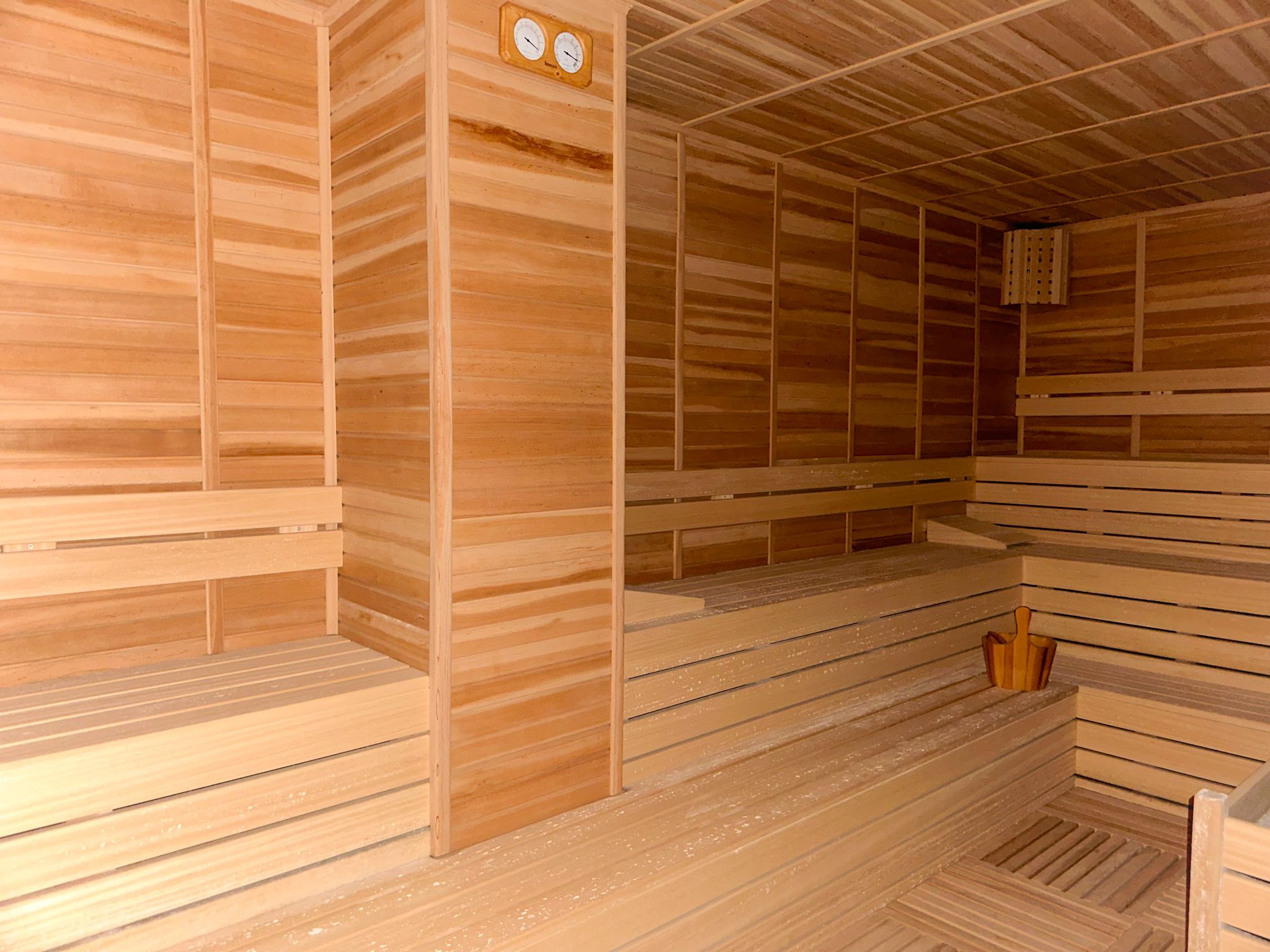 Sauna, dairelerin bulunduğu komplekste ahşap sedirler, soba ve kepçeli kova ile