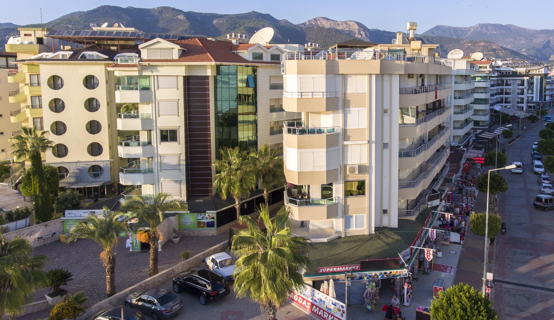 Dağ fonunda balkonlu akşam cephesi: Türkiye’nin Alanya kentinde Oba’da satılık 2+1 daire — New Level Group
