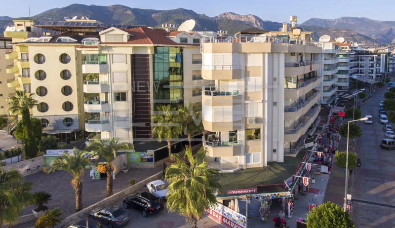 Dağ fonunda balkonlu akşam cephesi: Türkiye’nin Alanya kentinde Oba’da satılık 2+1 daire — New Level Group