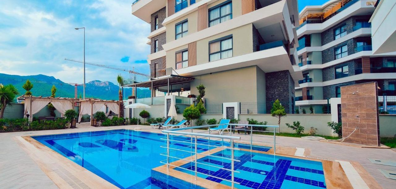 Blue pool beside balconies and mountains: a 1+1 apartment for sale in Oba, Alanya, Turkey — New Level Group