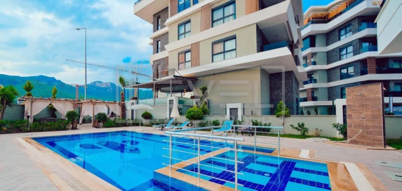 Blue pool beside balconies and mountains: a 1+1 apartment for sale in Oba, Alanya, Turkey — New Level Group