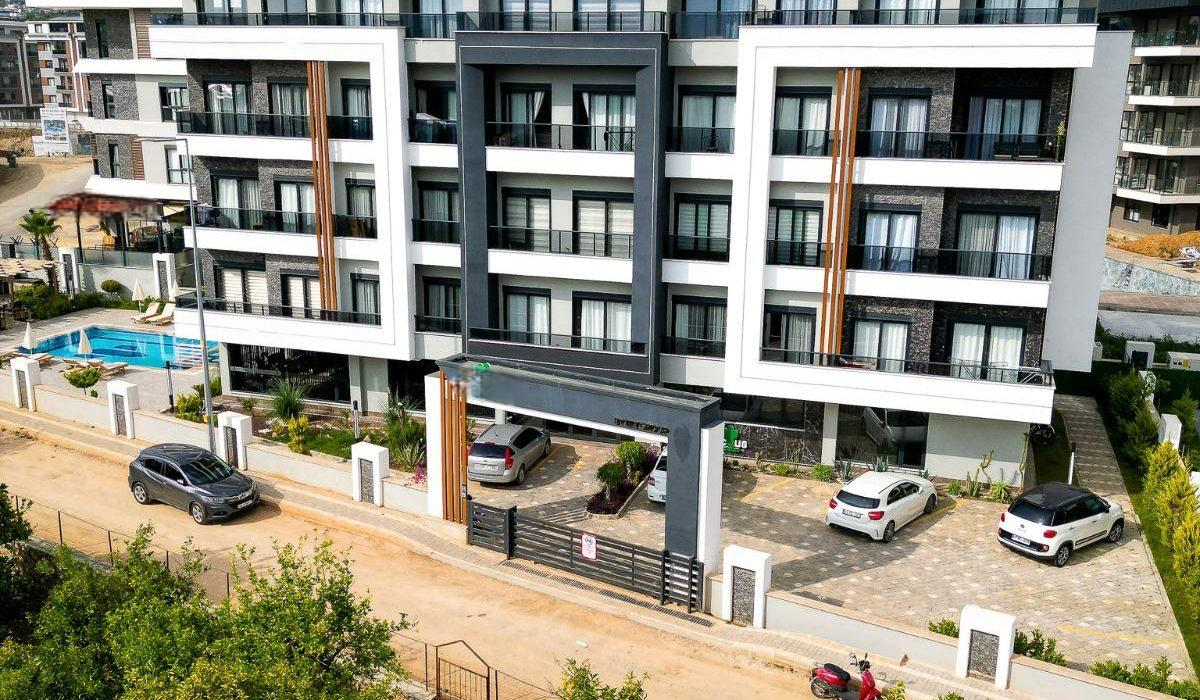 White and gray facade with black balcony railings and entry gates in Oba, where homes are for sale