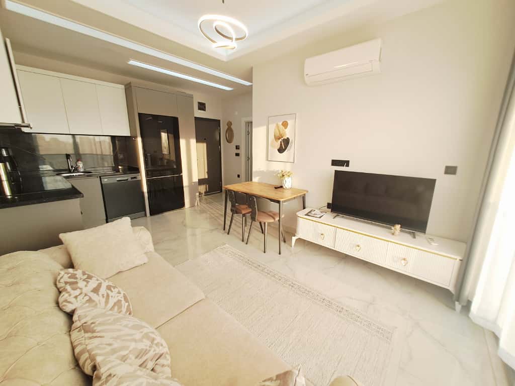 Kitchen-living room with a light corner sofa and white cabinetry in Alanya, Turkey