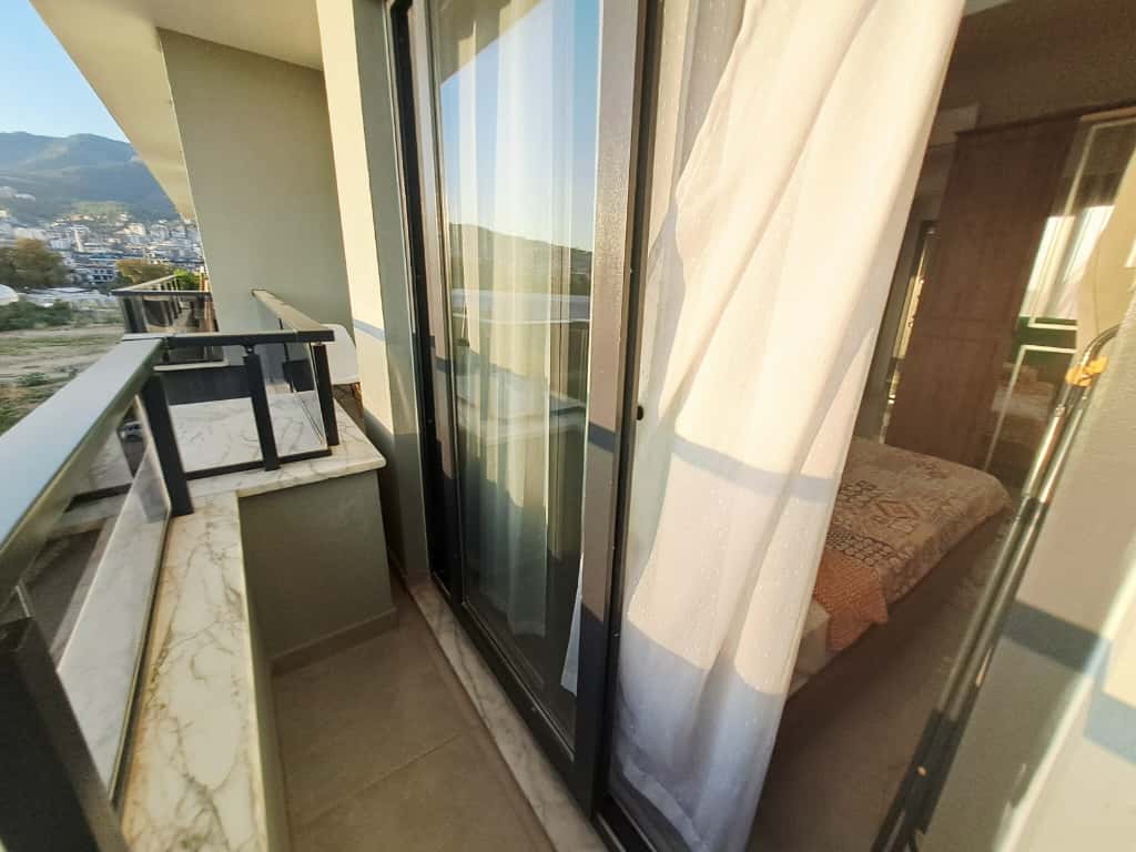 Balcony with a clear railing and mountain views over the city at an apartment in Alanya, Turkey