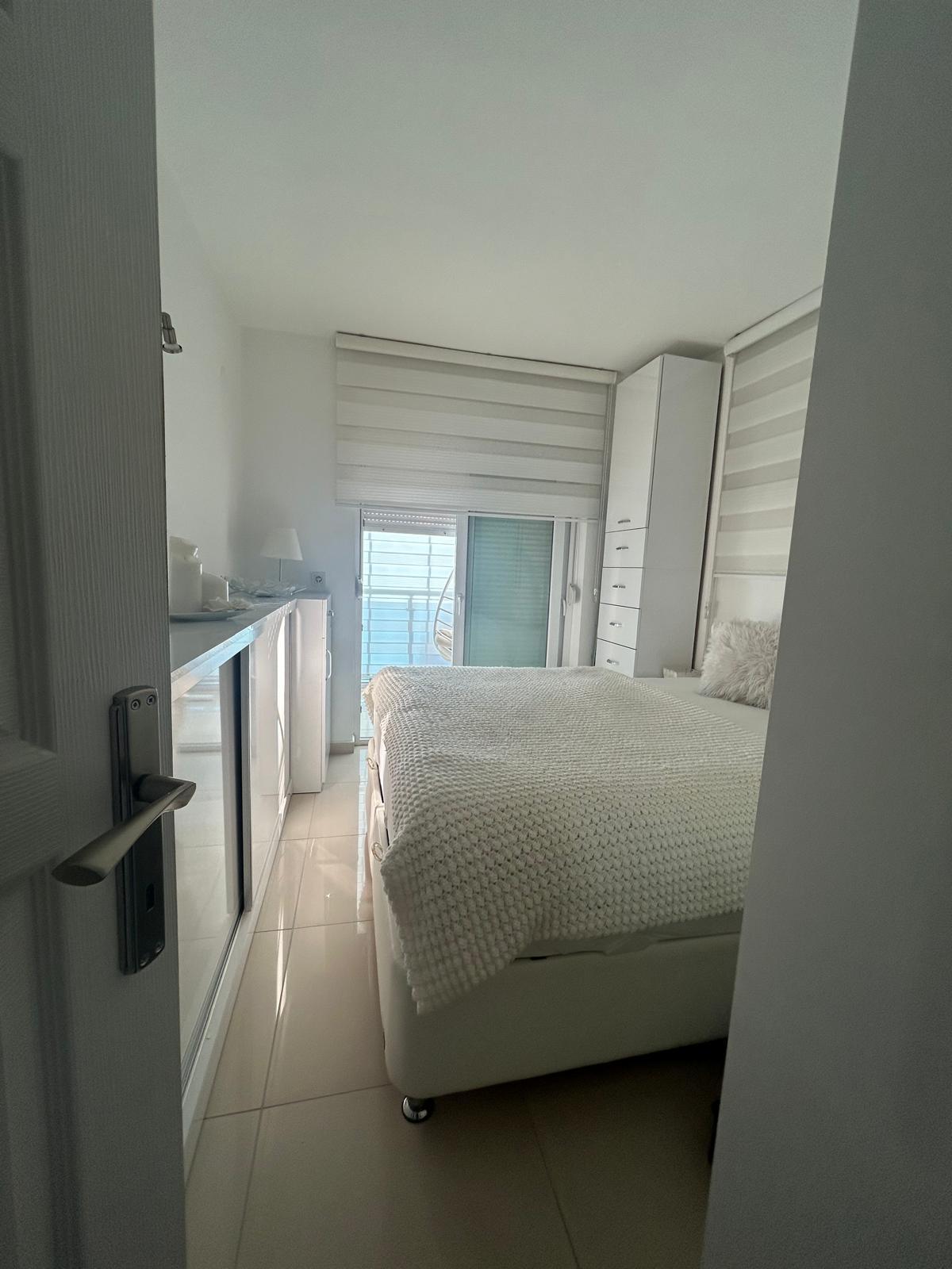 Panoramik pencereli yatak odası, Oba’daki konutta balkon camı ve çift kişilik yatakla