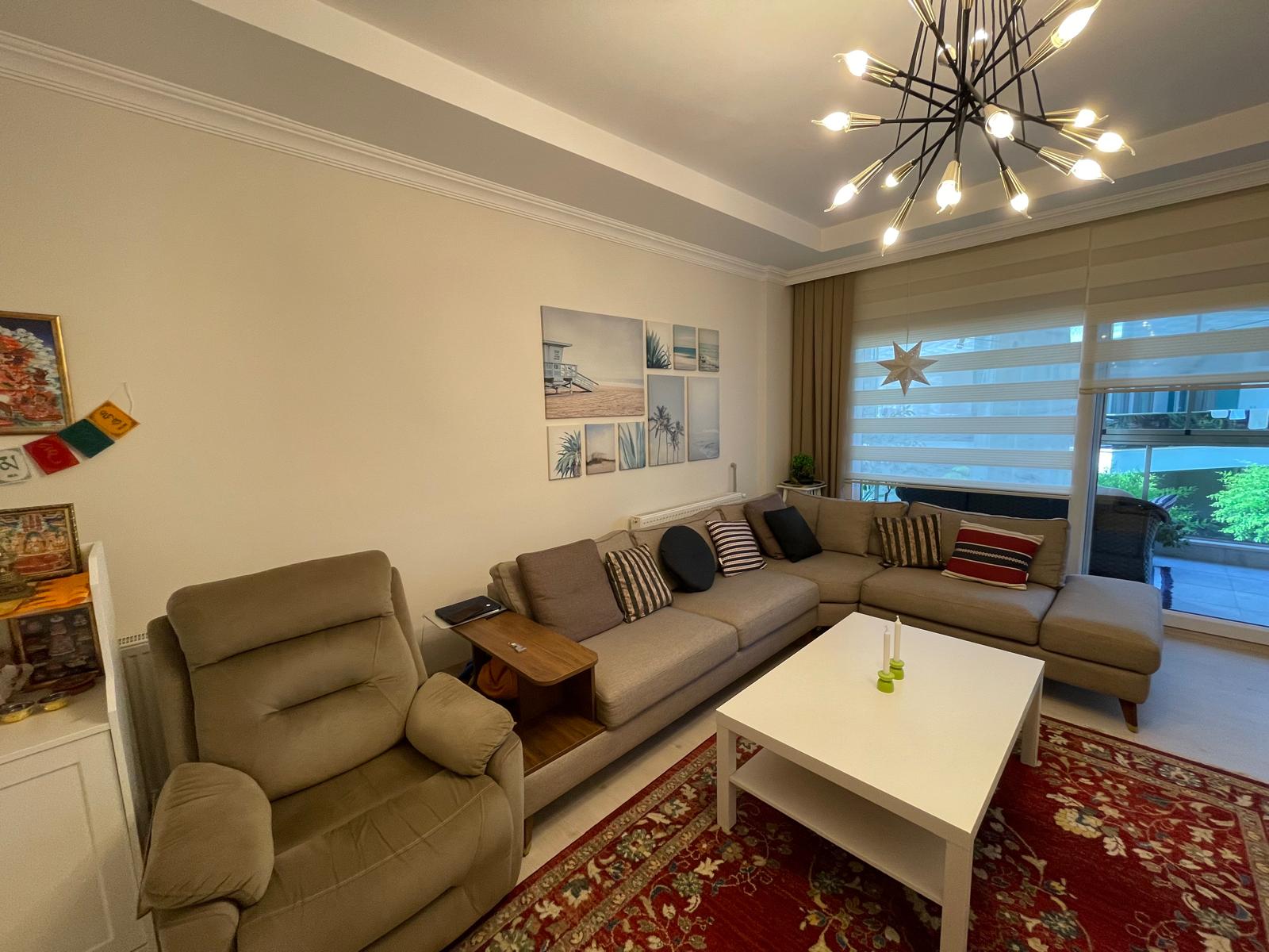 Gri köşe koltuklu salon ve çok katlı avize, Türkiye'de satılık rezidansta