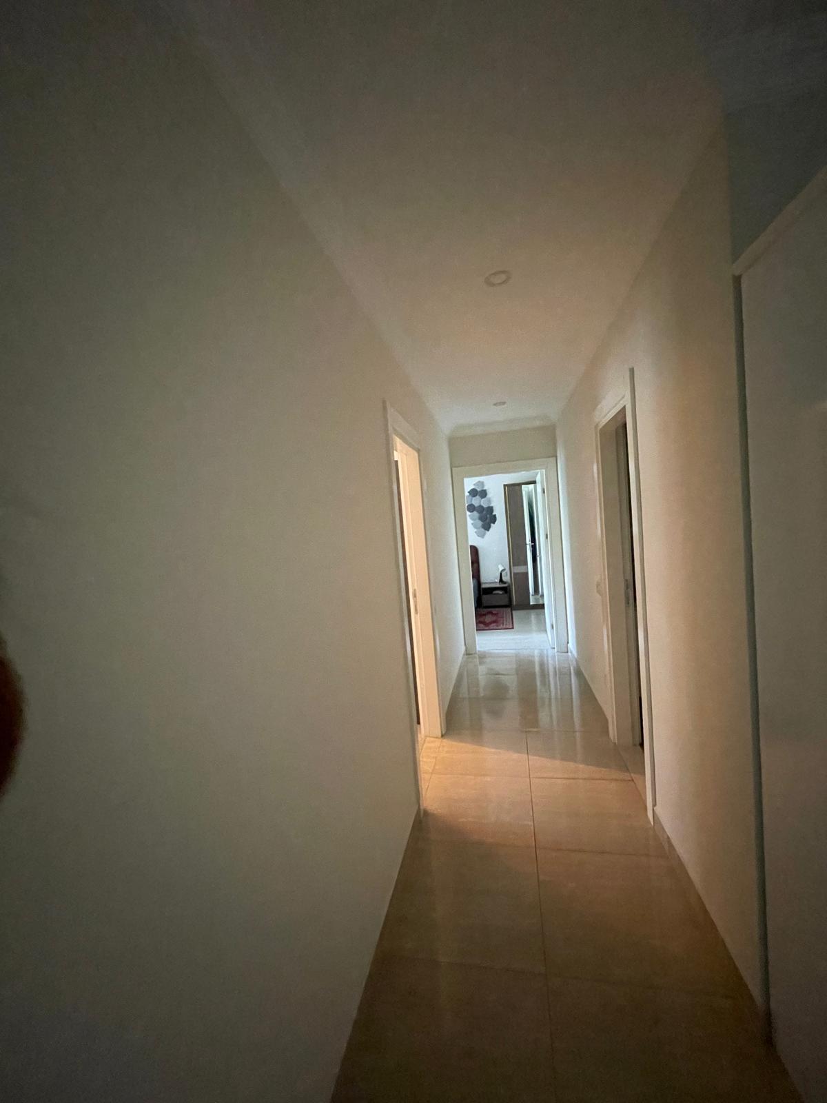 Açık renk fayanslı koridor ve gömme tavan ışıkları Oba'daki dairede