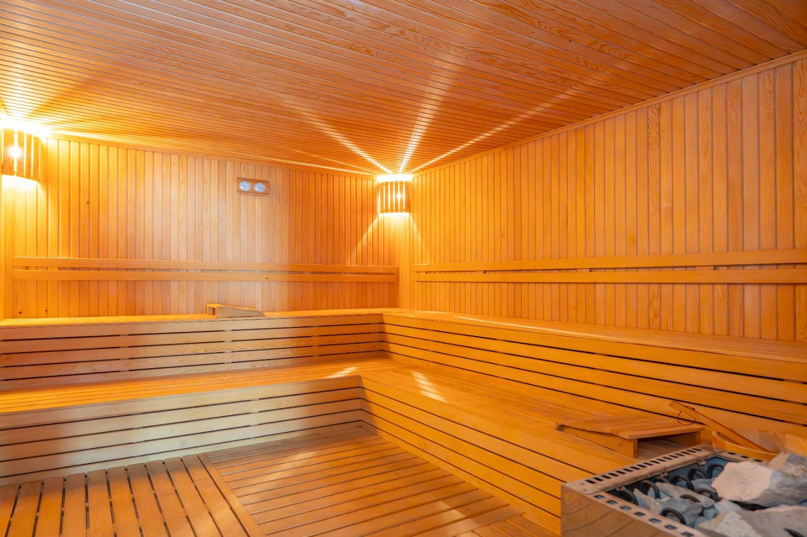 Ahşap raflı sauna ve köşedeki soba Oba'da
